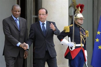 French President Hollande walks with Guinea's President Conde at the Elysee Palace in Paris